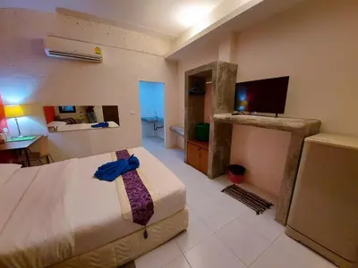 a bedroom with a bed and a television in it at 2 Home in Chalong