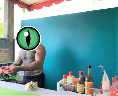 a man standing in a kitchen with a magnifying glass at 2 Home in Chalong