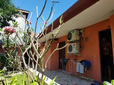 a house with a stove and clothes hanging on the wall at 2 Home in Chalong
