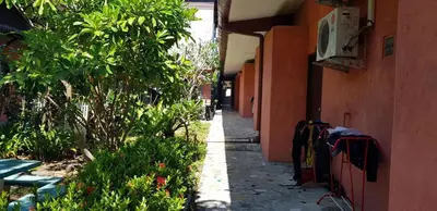 an alley with clothes hanging on the side of a building at 2 Home in Chalong