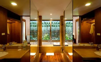 a bathroom with two sinks and a tub with a window at Nakamanda Resort and Spa in Klong Muang Beach