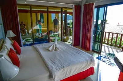 a bedroom with a bed with a person on a balcony at Dang Sea Beach Resort - SHA in Nai Yang Beach