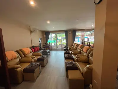 a living room filled with brown couches and chairs at Dang Sea Beach Resort - SHA in Nai Yang Beach