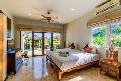 a bedroom with a bed and a large window at Aster Pool Villa Your Tropical Villa In Paradise in Rawai Beach