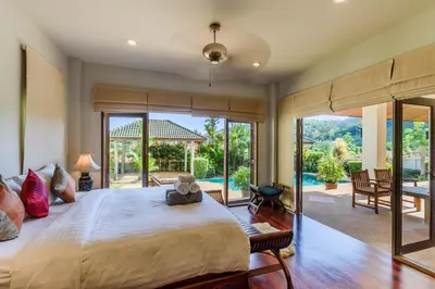 a bedroom with a large bed and a large window at Aster Pool Villa Your Tropical Villa In Paradise in Rawai Beach