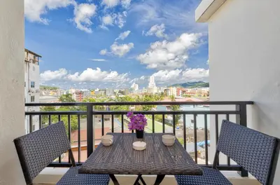 a table on a balcony with a view of a city at Lucky Buako Hotel Patong in Patong Beach