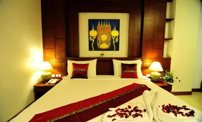 a bedroom with a large bed and two lamps at Arita Hotel Patong in Patong Beach