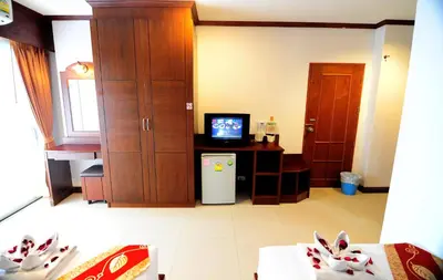 a living room with a television and a room with a table at Arita Hotel Patong in Patong Beach