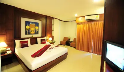 a bedroom with a large bed and a television at Arita Hotel Patong in Patong Beach