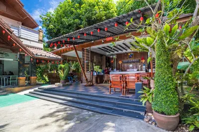 an outdoor patio with a bar and chairs at Phuket Meet Holiday Hotel-Rawai \u666e\u5409\u5c9b\u76f8\u9047\u82b1\u56ed\u5ea6\u5047\u9152\u5e97-\u62c9\u5a01\u5e97 in Rawai Beach