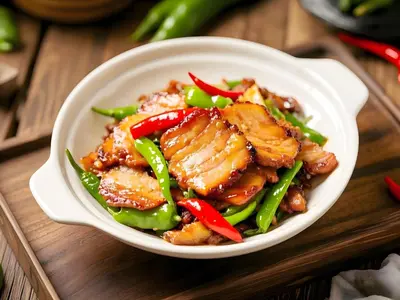 a bowl of chicken and vegetables on a wooden table at Phuket Meet Holiday Hotel-Rawai \u666e\u5409\u5c9b\u76f8\u9047\u82b1\u56ed\u5ea6\u5047\u9152\u5e97-\u62c9\u5a01\u5e97 in Rawai Beach