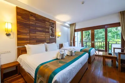 a hotel room with two beds and a balcony at Phuket Meet Holiday Hotel-Rawai \u666e\u5409\u5c9b\u76f8\u9047\u82b1\u56ed\u5ea6\u5047\u9152\u5e97-\u62c9\u5a01\u5e97 in Rawai Beach