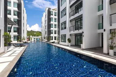 a swimming pool in the middle of two buildings at Kamala Regent Residence in Kamala Beach