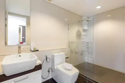 a bathroom with a toilet and a sink and a shower at Kamala Regent Residence in Kamala Beach