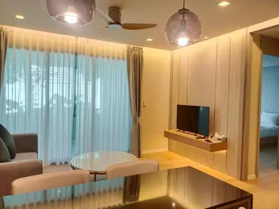 a living room with a couch and a tv at The Regent Residence Kamala in Kamala Beach
