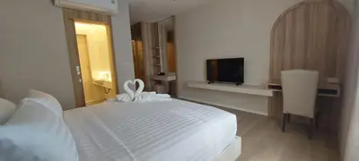 a bedroom with a white bed and a television at The Regent Residence Kamala in Kamala Beach