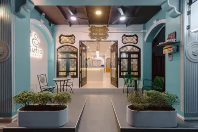 a store with blue walls and tables and chairs at Baan Sutra Guesthouse in Phuket Town
