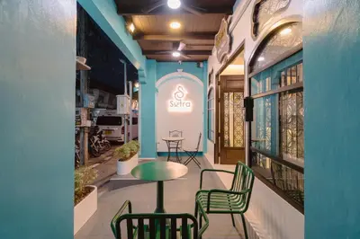 a cafe with chairs and a table in a building at Baan Sutra Guesthouse in Phuket Town