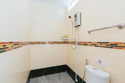 a bathroom with a toilet and a shower at Baan Sutra Guesthouse in Phuket Town