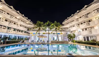 a large building with a swimming pool at night at Blue Carina Hotel Phuket in Phuket Town