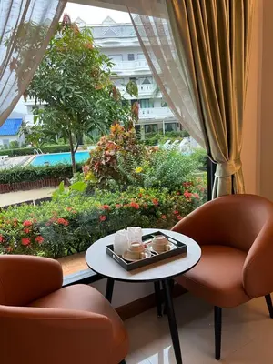 a room with two chairs and a table and a window at Blue Carina Hotel Phuket in Phuket Town