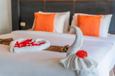 two swans are sitting on top of a bed at Blue Carina Hotel Phuket in Phuket Town