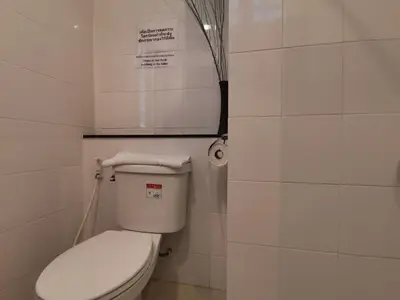 a bathroom with a toilet with a sign above it at Le Desir Resortel in Chalong
