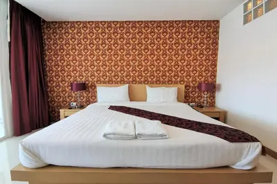 a bedroom with a bed with two towels on it at Le Desir Resortel in Chalong