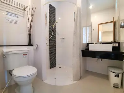 a white bathroom with a toilet and a sink at Le Desir Resortel in Chalong