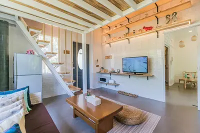 a living room with a refrigerator and a table at Perennial Resort in Nai Yang Beach