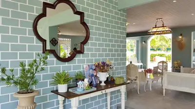 a blue brick wall with a mirror and a table at Perennial Resort in Nai Yang Beach