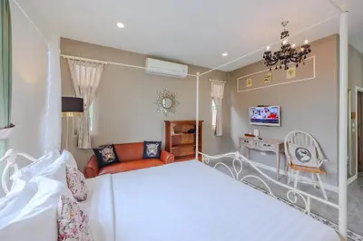 a bedroom with a bed and a living room at Perennial Resort in Nai Yang Beach