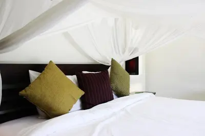 a bedroom with a white bed with pillows at One Bedroom Oriental Villa Nai Harn in Nai Harn Beach