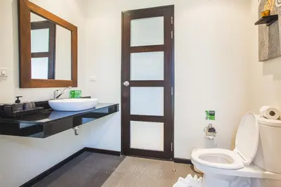 a bathroom with a toilet and a sink at Two Bedroom Oriental Villa Nai Harn in Nai Harn Beach