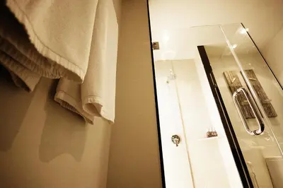 a bathroom with a shower and a mirror and a towel at Two Bedroom Oriental Villa Nai Harn in Nai Harn Beach