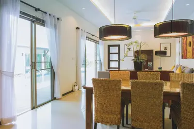 a dining room with a table and chairs at Two Bedroom Oriental Villa Nai Harn in Nai Harn Beach