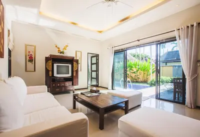 a living room with white furniture and a tv at Two Bedroom Oriental Villa Nai Harn in Nai Harn Beach
