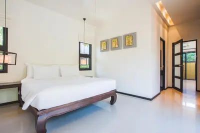 a bedroom with a large white bed in a room at Two Bedroom Oriental Villa Nai Harn in Nai Harn Beach