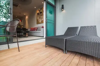 a couch and a chair on a wooden floor at ONYX Villa Naiharn - 1 Bedroom with private pool in Nai Harn Beach
