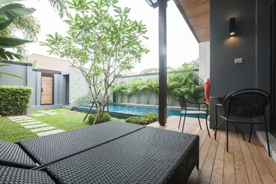 a patio with a table and chairs and a swimming pool at ONYX Villa Naiharn - 1 Bedroom with private pool in Nai Harn Beach