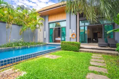 a villa with a swimming pool and a house at ONYX Villa Naiharn - 1 Bedroom with private pool in Nai Harn Beach