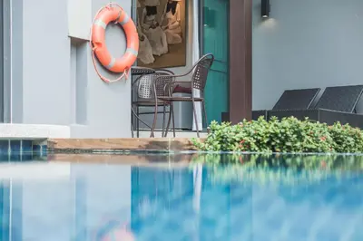 a swimming pool with chairs and a lifesaver on a house at ONYX Villa Naiharn - 2 Bedrooms with private pool in Nai Harn Beach