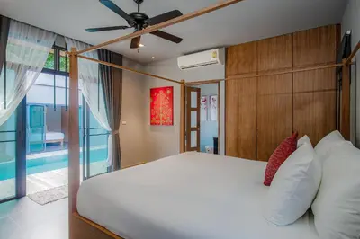 a bedroom with a bed and a ceiling fan at ONYX Villa Naiharn - 3 Bedrooms with private pool in Nai Harn Beach