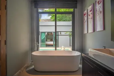 a large bath tub in a bathroom with a window at ONYX Villa Naiharn - 3 Bedrooms with private pool in Nai Harn Beach
