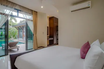a bedroom with a large white bed and a balcony at ONYX Villa Naiharn - 3 Bedrooms with private pool in Nai Harn Beach