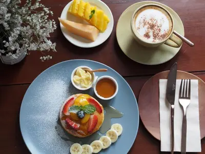 a table with plates of food and a cup of coffee at ONYX Villa Naiharn - 3 Bedrooms with private pool in Nai Harn Beach