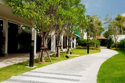 a walkway in front of a house with trees at Villa 3 Bedrooms with private pool at Oxygen Bangtao in Bang Tao Beach