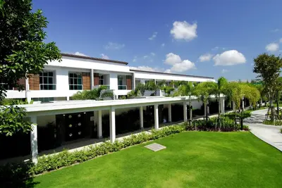 a large white building with a lawn in front of it at Villa 3 Bedrooms with private pool at Oxygen Bangtao in Bang Tao Beach