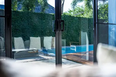 a glass door leading to a swimming pool at Villa 1 Bedroom with private pool at Wings Pasak in Bang Tao Beach