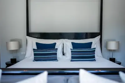 a bedroom with a bed with blue and white pillows at Villa 2 Bedrooms with private pool at Wings Pasak in Bang Tao Beach